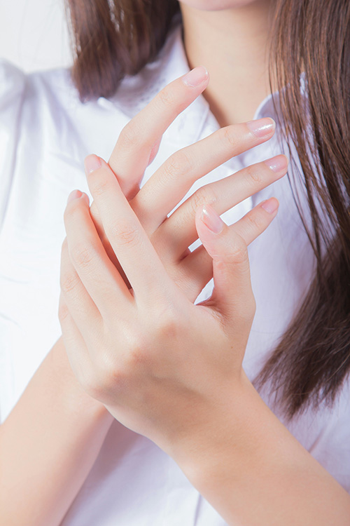 Woman rubbing lotion into hands, using the best diabetic lotion for dry skin on hands and feet