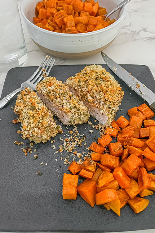 easy oven baked pork chops after cooking, with a side of sweet potato